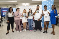 Whitney Walker, Lead Community Relations Specialist with NextEra Energy/FPL (far left), and Jasmine Govan, Community Relations Specialist for NextEra Energy/FPL (far right), pose with the winning team of a Generator Build Competition.