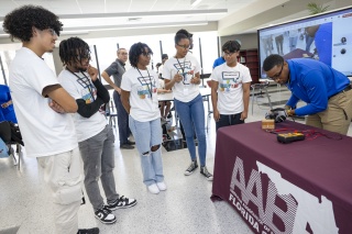 Stephen Fitch, IT Business Systems Analyst with Florida Power & Light Company (FPL), tests the voltage produced by a handmade electric generator as part of the Generator Build Competition.