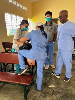 Dr. Roger Phanord of Phanord & Associates, right, observes dental students providing care during a missionary trip to Las Matas de Farfan, Dominican Republic.